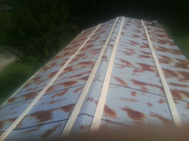 Rusted metal roof panels with new wood purlins before replacement — Storm Damage Roof Repair in Prides Crossing by Roofing Brothers