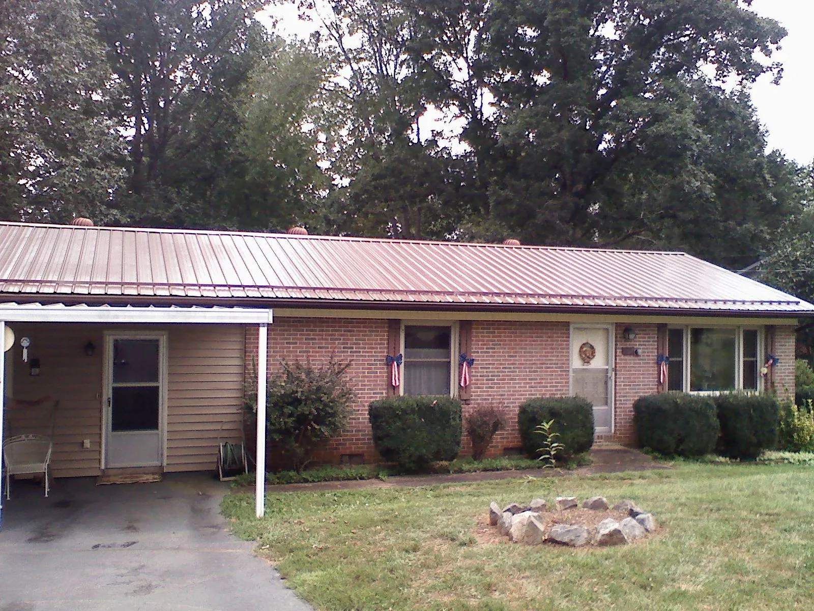 Bronze metal roof and carport on a brick ranch home — Roof Repair work by our crew in Prides Crossing