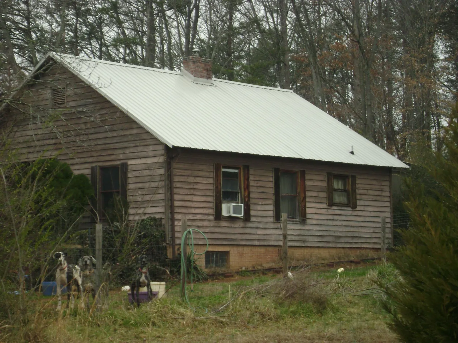 White metal roof on an old wood sided farmhouse, from a Metal Roof Installation job in Prides Crossing